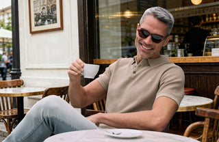 Mann trinkt Kaffee in einem Cafè im beigen Shirt
